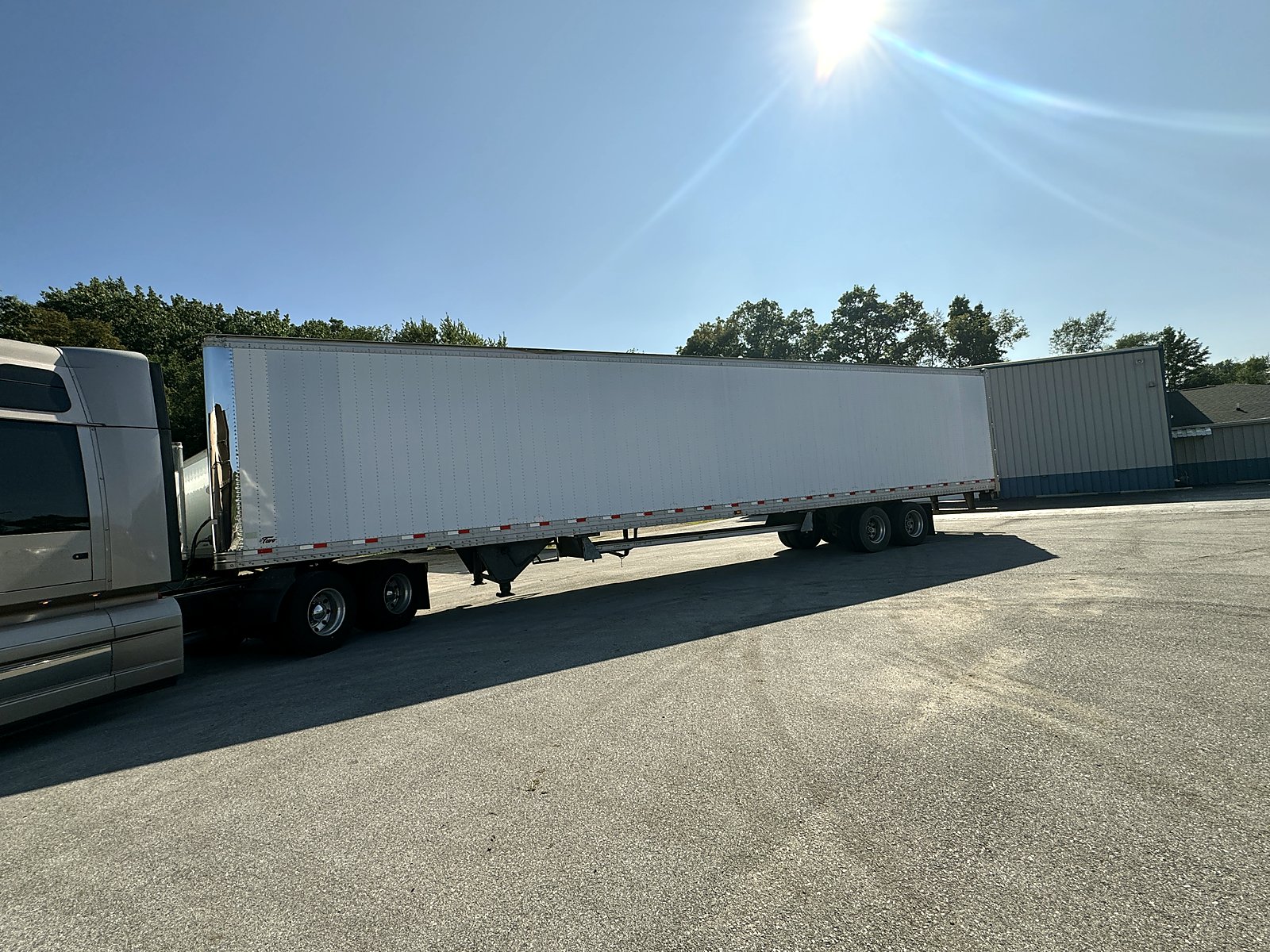 White dry van trailer hooked to a CW tractor